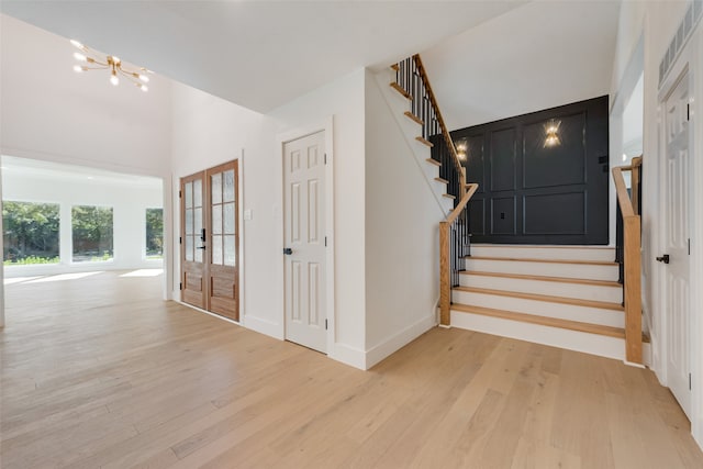 stairway featuring an inviting chandelier, hardwood / wood-style flooring, and french doors