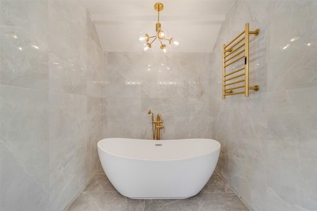 bathroom with a tub to relax in, tile walls, vaulted ceiling, and an inviting chandelier