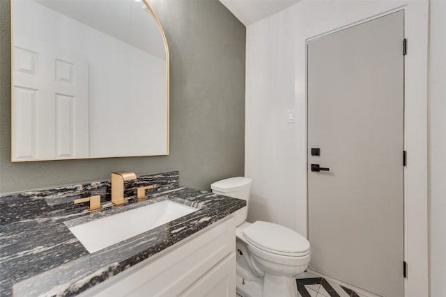 bathroom featuring tile patterned flooring, vanity, and toilet