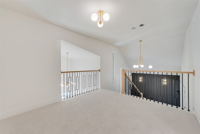 hall featuring an inviting chandelier, vaulted ceiling, and carpet floors