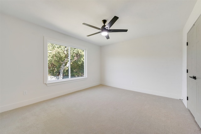 empty room featuring ceiling fan and light colored carpet