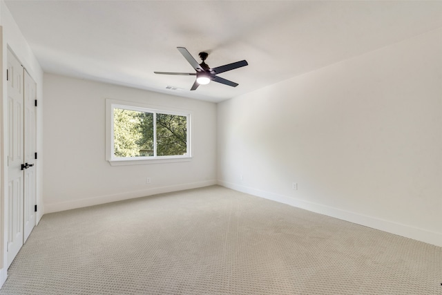 unfurnished room with ceiling fan and light colored carpet