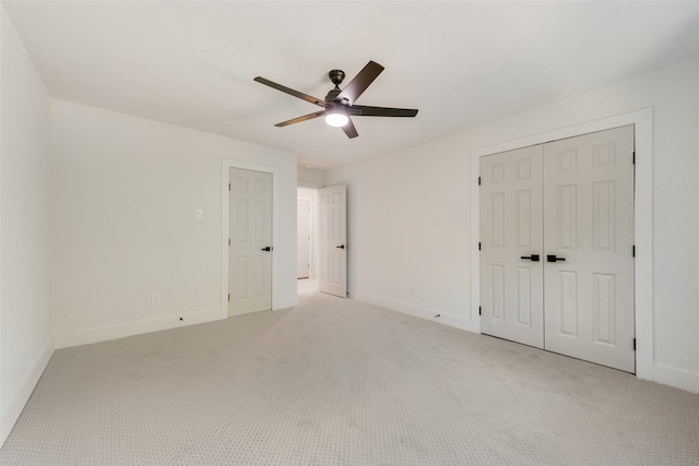 unfurnished bedroom with ceiling fan, light colored carpet, and a closet