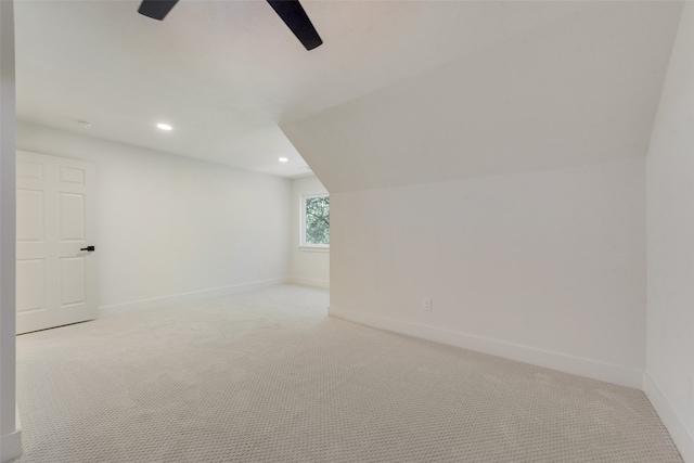 additional living space with vaulted ceiling, light carpet, and ceiling fan