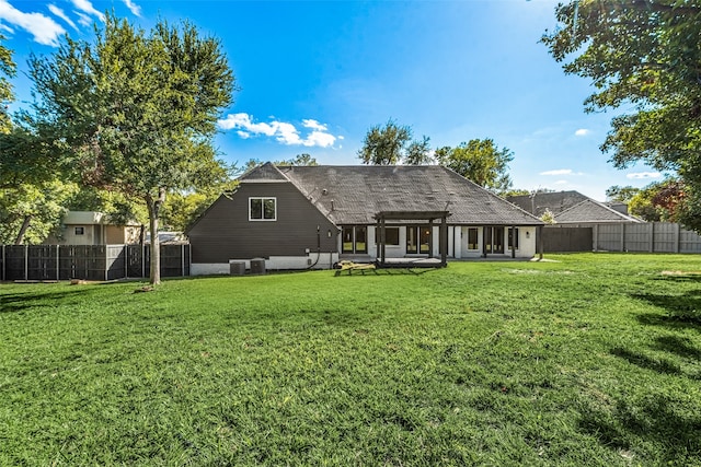 rear view of property featuring a yard and central AC unit