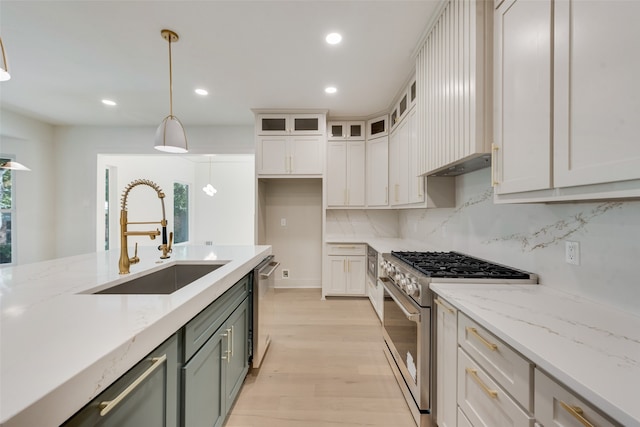 kitchen featuring pendant lighting, sink, white cabinetry, appliances with stainless steel finishes, and a healthy amount of sunlight