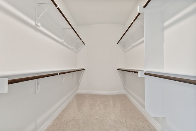 walk in closet featuring light carpet