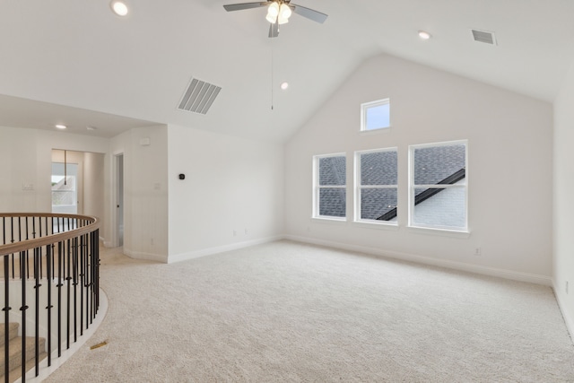 carpeted empty room with high vaulted ceiling and ceiling fan