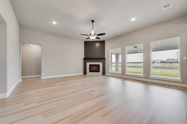 unfurnished living room with light hardwood / wood-style floors, a fireplace, and ceiling fan