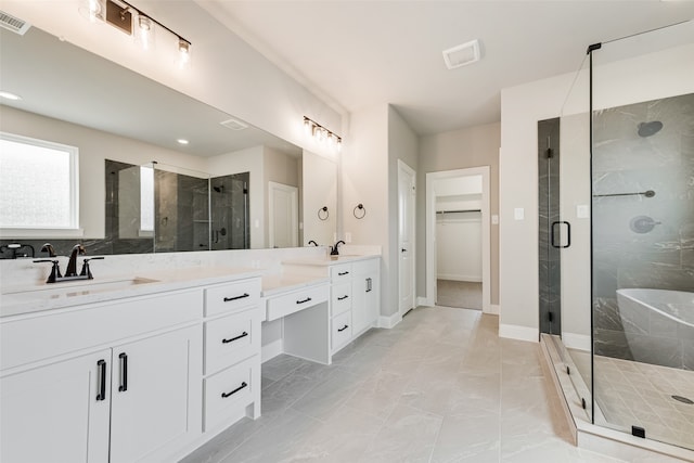 bathroom featuring a shower with door and vanity