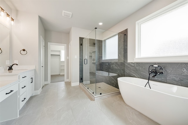 bathroom with vanity and separate shower and tub