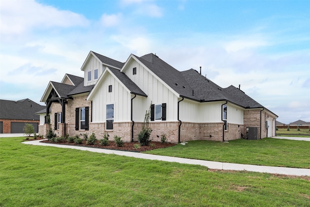 view of front of property featuring a front yard, a garage, and central air condition unit