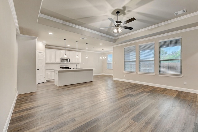 unfurnished living room featuring a raised ceiling, ceiling fan, and hardwood / wood-style flooring