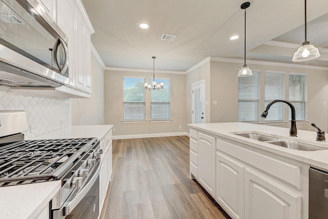 kitchen featuring wood-type flooring, sink, stainless steel appliances, and white cabinets