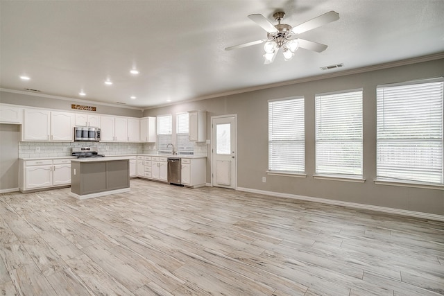 kitchen with appliances with stainless steel finishes, light hardwood / wood-style floors, ceiling fan, and white cabinets