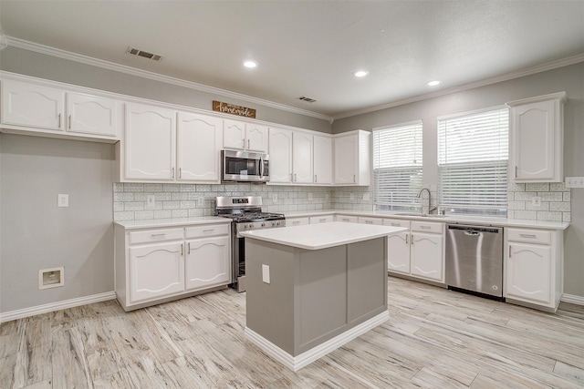 kitchen featuring a center island, sink, white cabinets, light hardwood / wood-style flooring, and stainless steel appliances