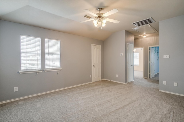 carpeted spare room featuring vaulted ceiling and ceiling fan