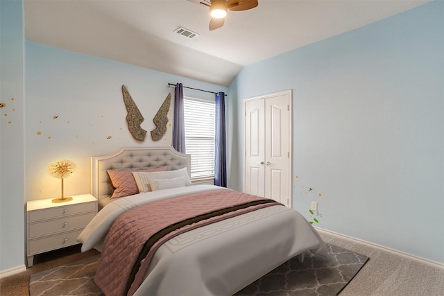 bedroom featuring ceiling fan, a closet, dark colored carpet, and vaulted ceiling