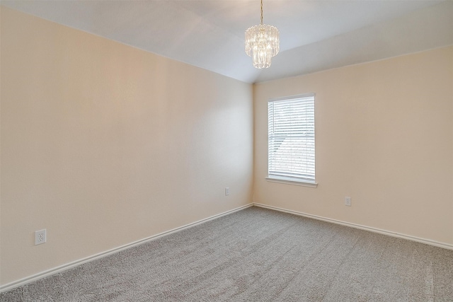 carpeted empty room featuring vaulted ceiling and a chandelier