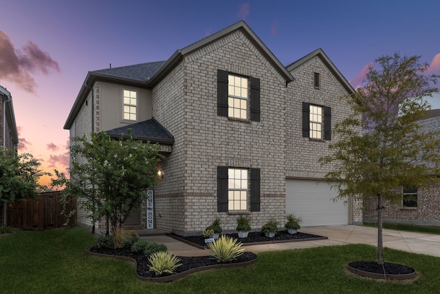 front facade featuring a lawn and a garage