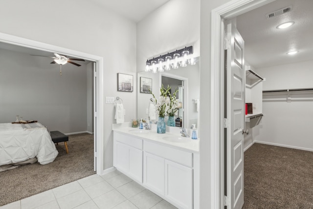 bathroom featuring tile patterned floors, ceiling fan, vanity, and a textured ceiling