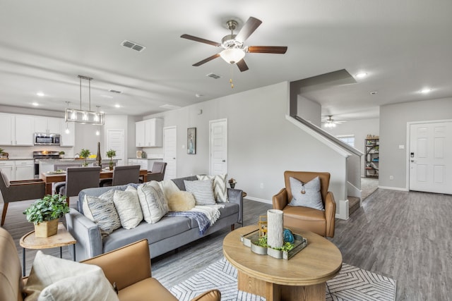 living room with ceiling fan and dark wood-type flooring