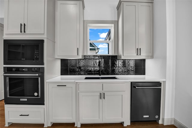 kitchen with white cabinetry, sink, and tasteful backsplash