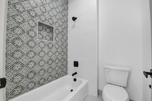 bathroom featuring toilet and tiled shower / bath