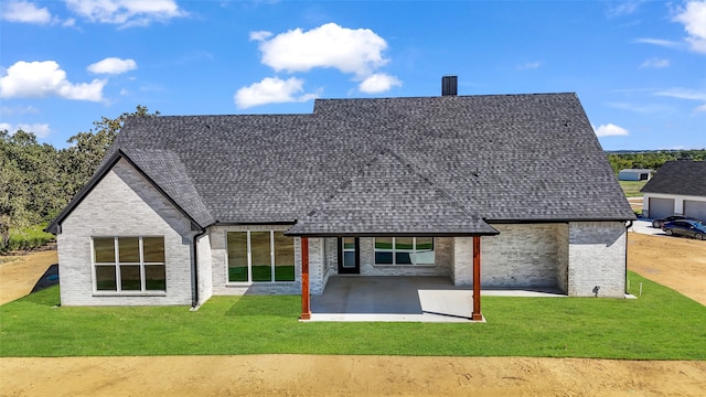 back of property featuring a patio and a yard