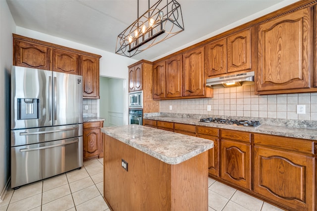 kitchen featuring pendant lighting, a kitchen island, a chandelier, stainless steel appliances, and decorative backsplash