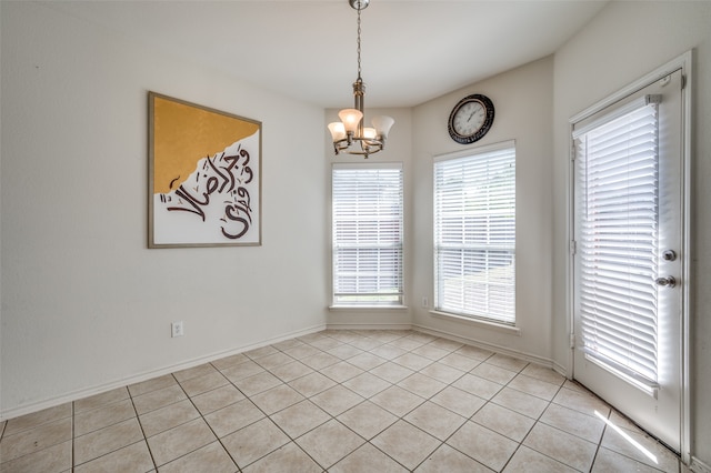 spare room with light tile patterned flooring and a chandelier