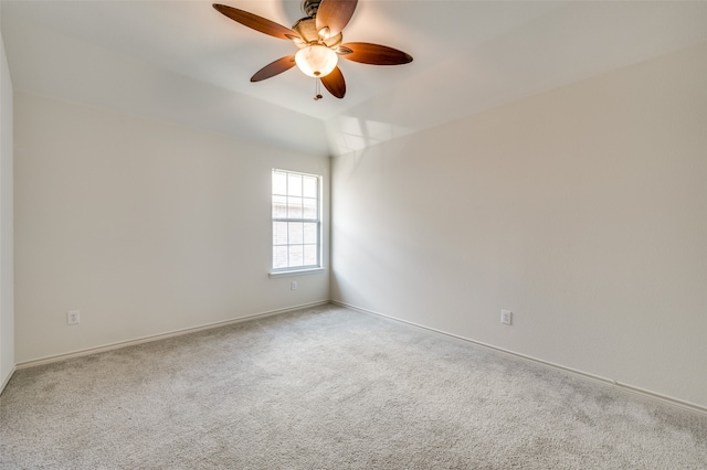 carpeted spare room featuring vaulted ceiling and ceiling fan