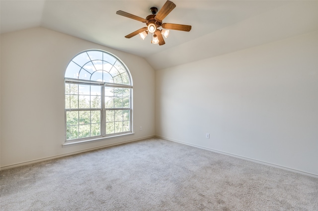 spare room featuring light carpet, lofted ceiling, ceiling fan, and a healthy amount of sunlight