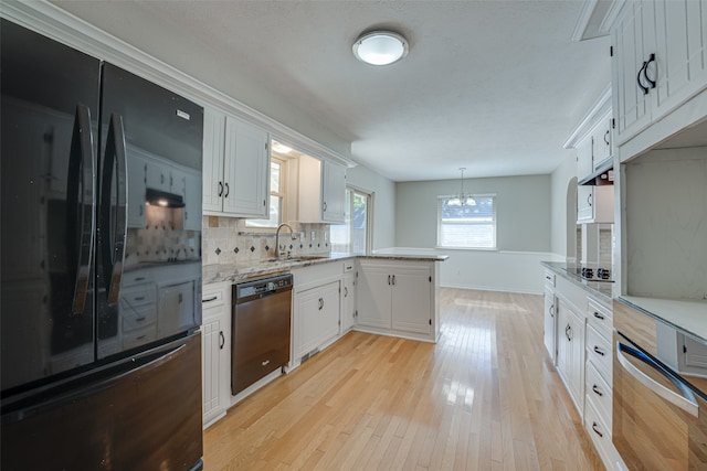 kitchen with black appliances, pendant lighting, and white cabinets