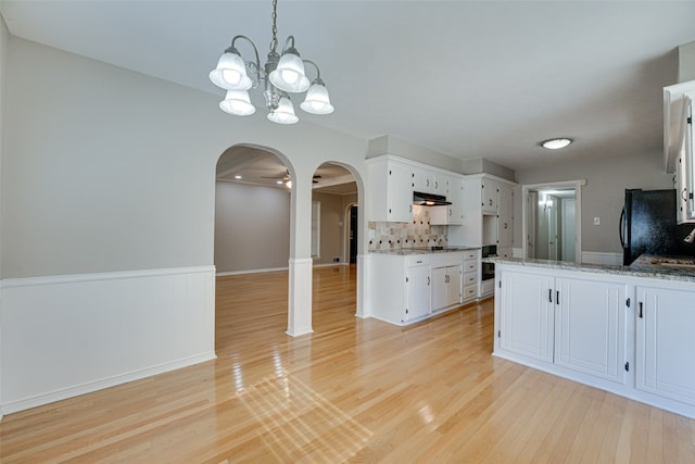 kitchen featuring light hardwood / wood-style floors, white cabinetry, a chandelier, and black refrigerator