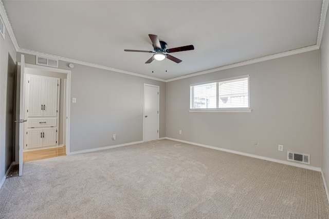 unfurnished bedroom featuring carpet floors, ornamental molding, and ceiling fan