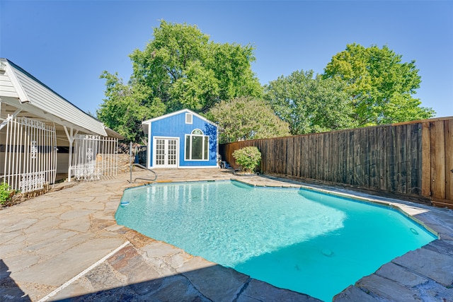 view of swimming pool with a patio area and an outbuilding