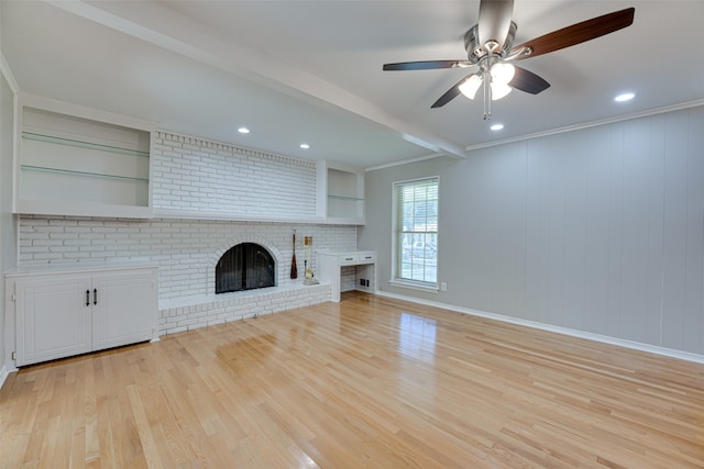 unfurnished living room with light hardwood / wood-style floors, beam ceiling, a fireplace, ornamental molding, and ceiling fan