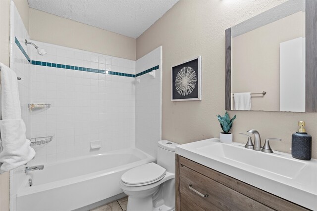 full bathroom featuring vanity, a textured ceiling, tiled shower / bath combo, toilet, and tile patterned floors