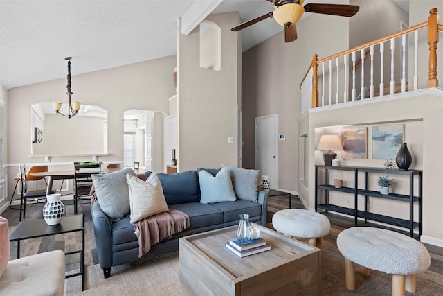 living room featuring a textured ceiling, ceiling fan with notable chandelier, hardwood / wood-style floors, and high vaulted ceiling