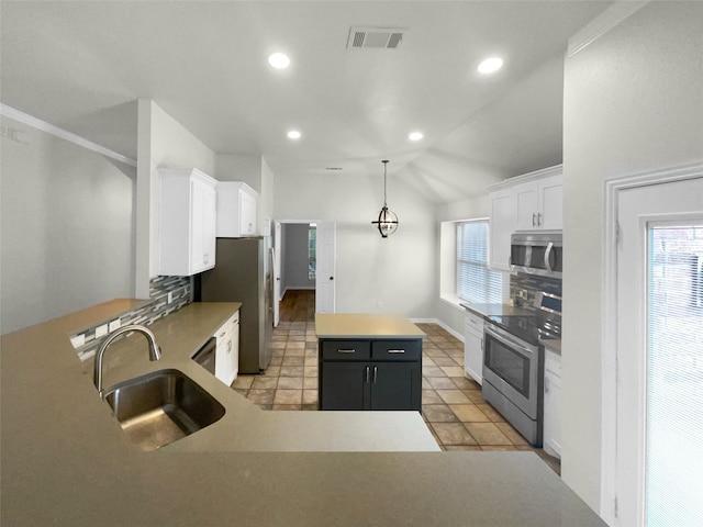 kitchen featuring appliances with stainless steel finishes, white cabinetry, a center island, and sink