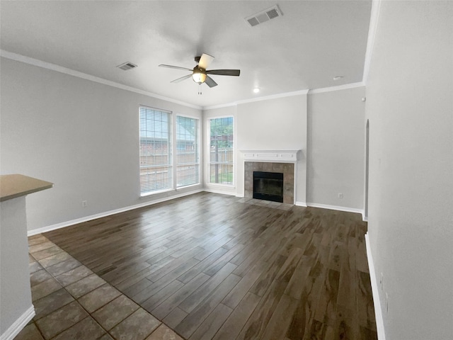 unfurnished living room with ceiling fan, a fireplace, crown molding, and dark hardwood / wood-style flooring