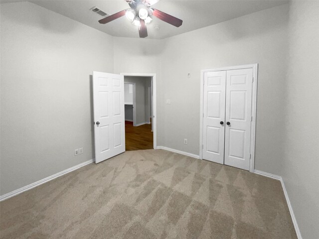 unfurnished bedroom featuring carpet flooring, ceiling fan, and a closet