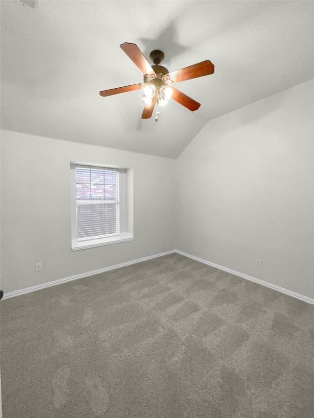 spare room with carpet, vaulted ceiling, and ceiling fan