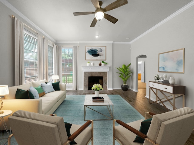 living room with a tile fireplace, ornamental molding, dark hardwood / wood-style floors, and ceiling fan