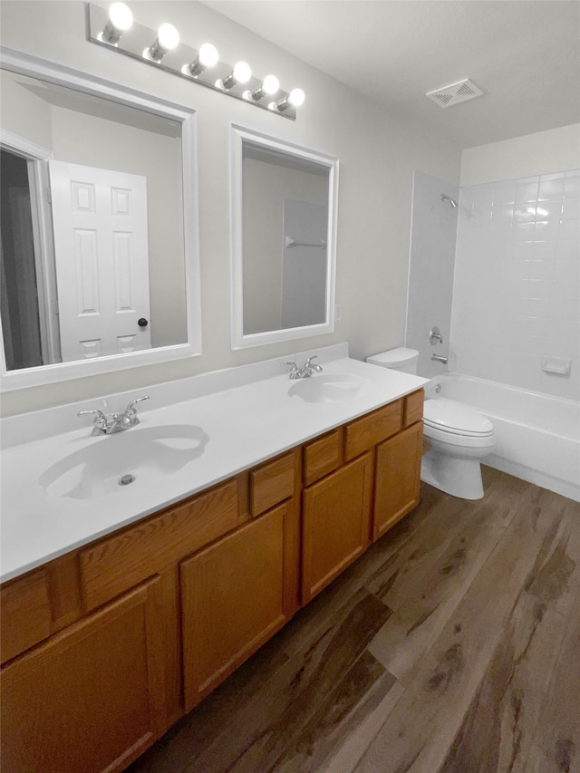 full bathroom featuring vanity, hardwood / wood-style flooring, toilet, and shower / washtub combination