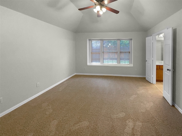 interior space with vaulted ceiling, light carpet, and ceiling fan