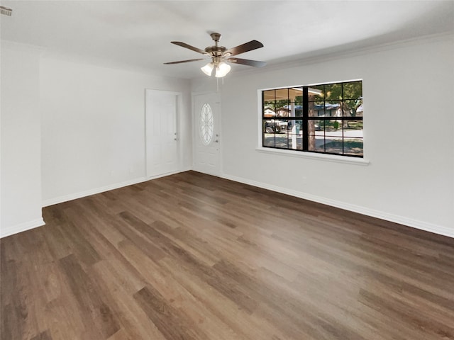 spare room with crown molding, dark hardwood / wood-style floors, and ceiling fan