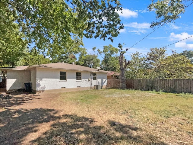 back of house featuring a yard and central AC