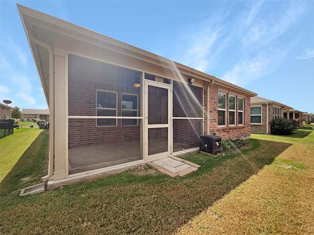 rear view of property featuring a lawn